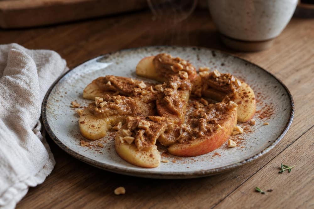 Appelschijfjes met pindakaas en kaneel